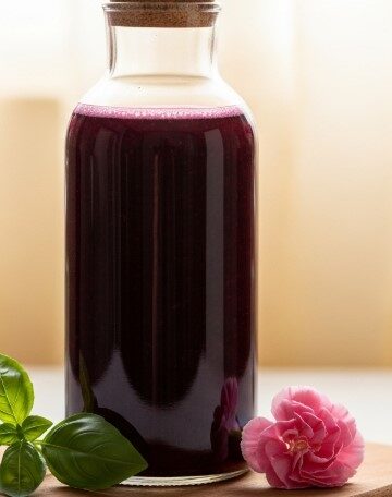 Herbal Cordial Recipe Blueberry Basil Cordial in glass bottle on wooden board